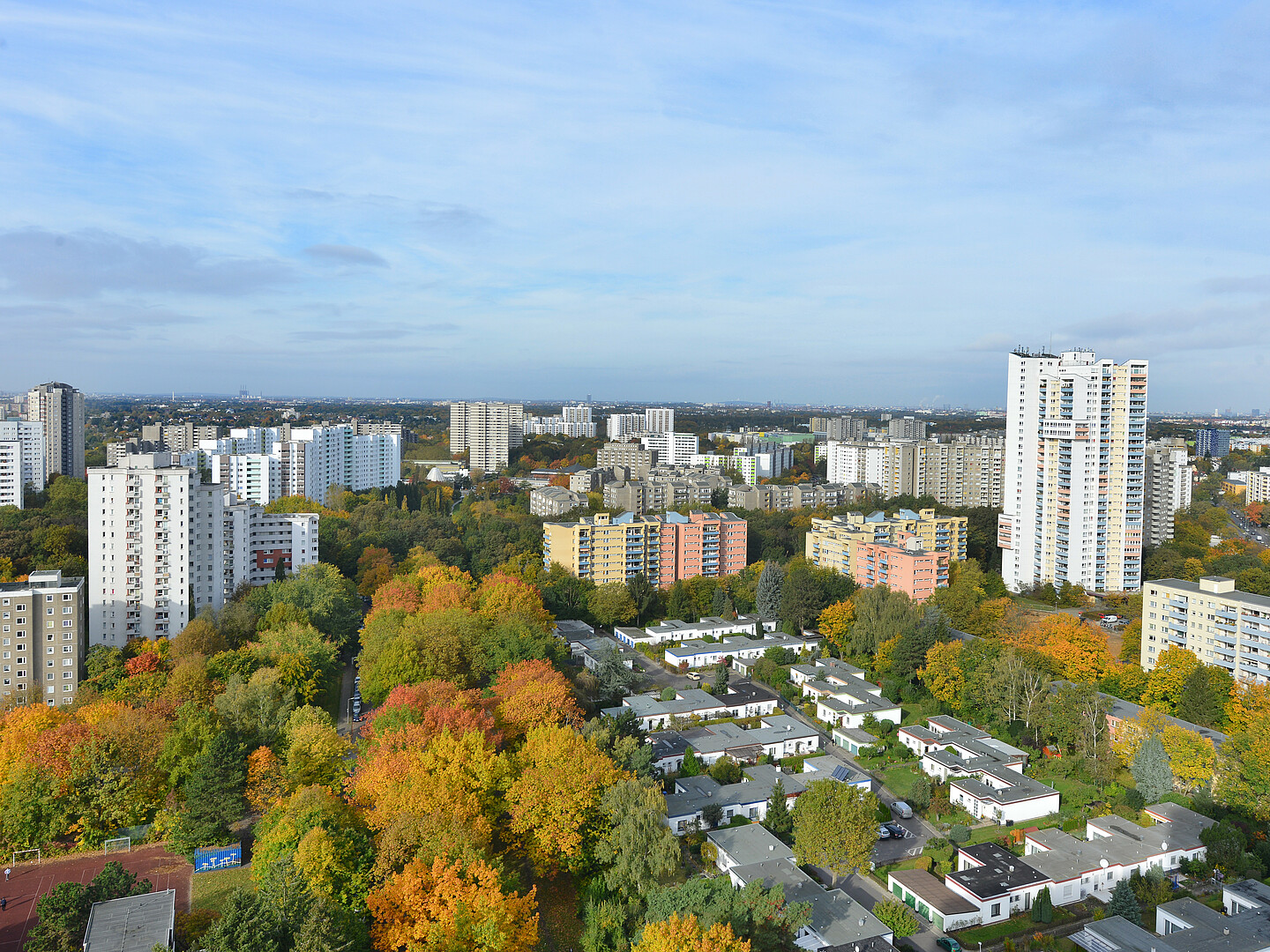 Eine Panoramaaufnahme von Gropiusstadt. Im Vordergrund sind kleinere Häuser zu sehen, umringt von Hochhäusern.