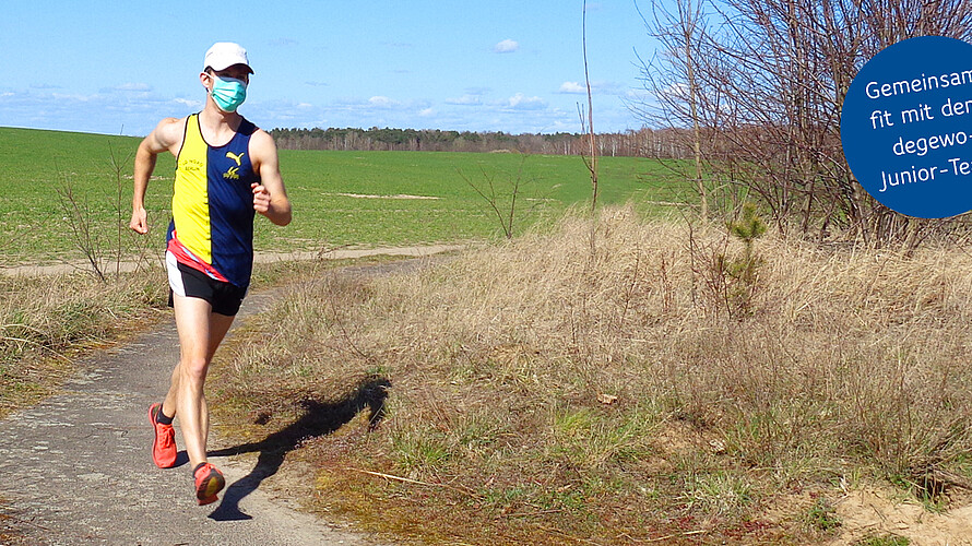 Mann joggt am Feldweg.