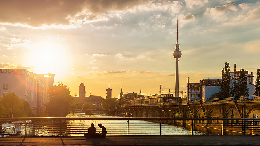 Die Sonne verschwindet im unteren Drittel des Bildes hinter der Berliner Skyline.