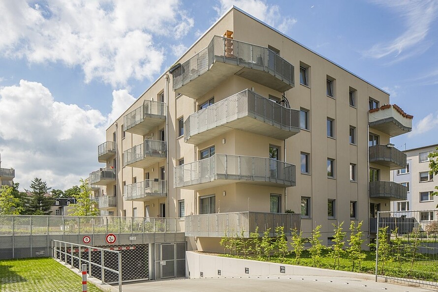 Blick auf ein mehrstöckiges Haus bei Sonnenschein und blauem Himmel.