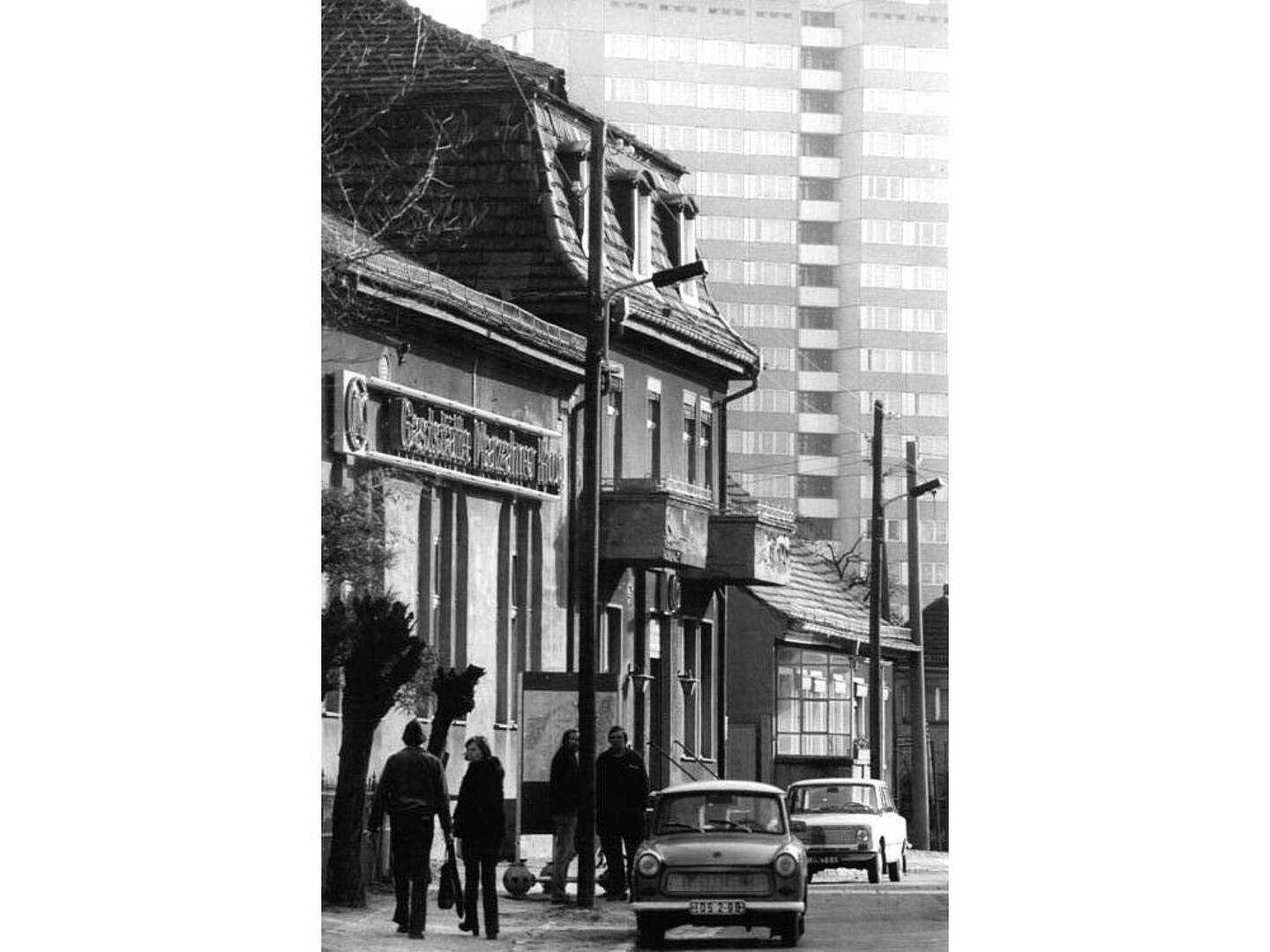 Berlin-Marzahn in der Vergangenheit. Ein paar Passanten ging durch die Straße. Auf der Straße gab es auch ein Auto.