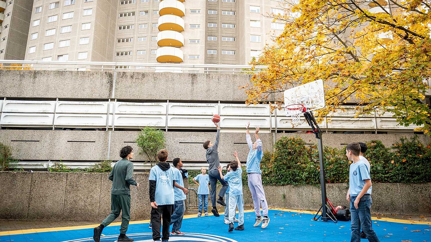 Kinder spielen Basketball draußen