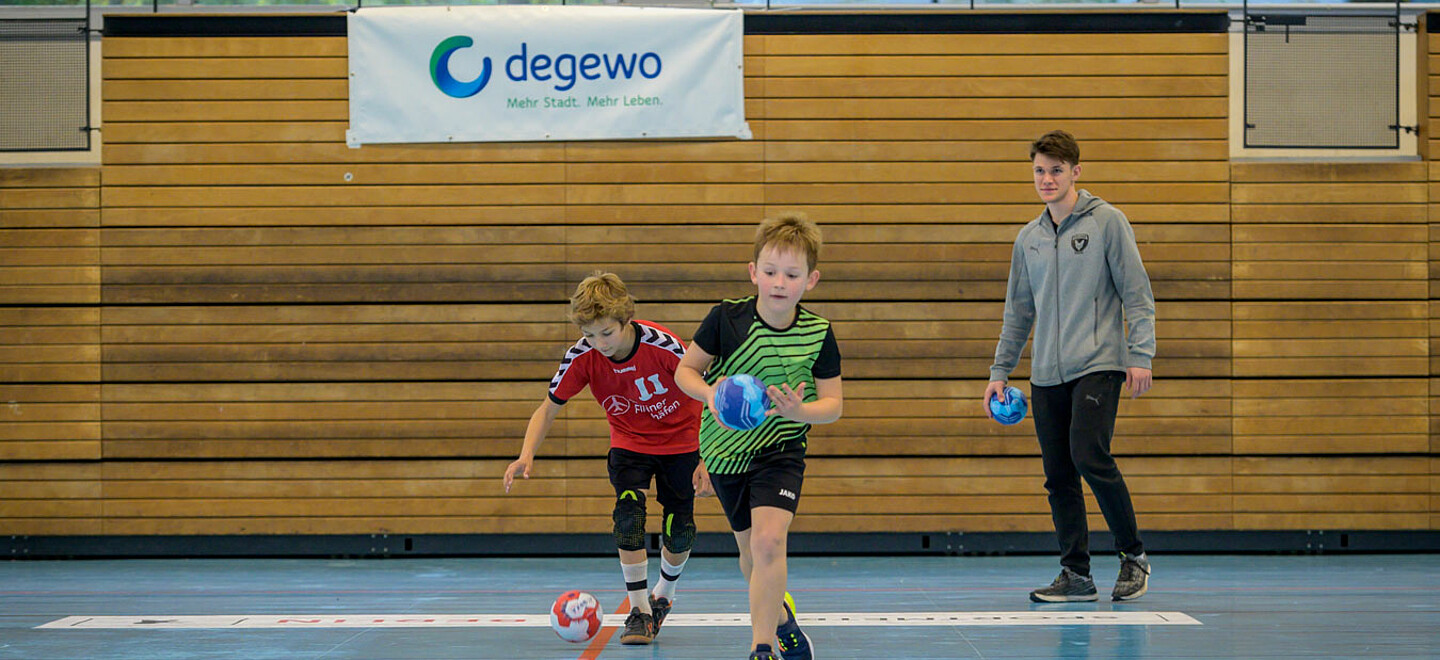 Zwei Jungen laufen und halten den Ball.