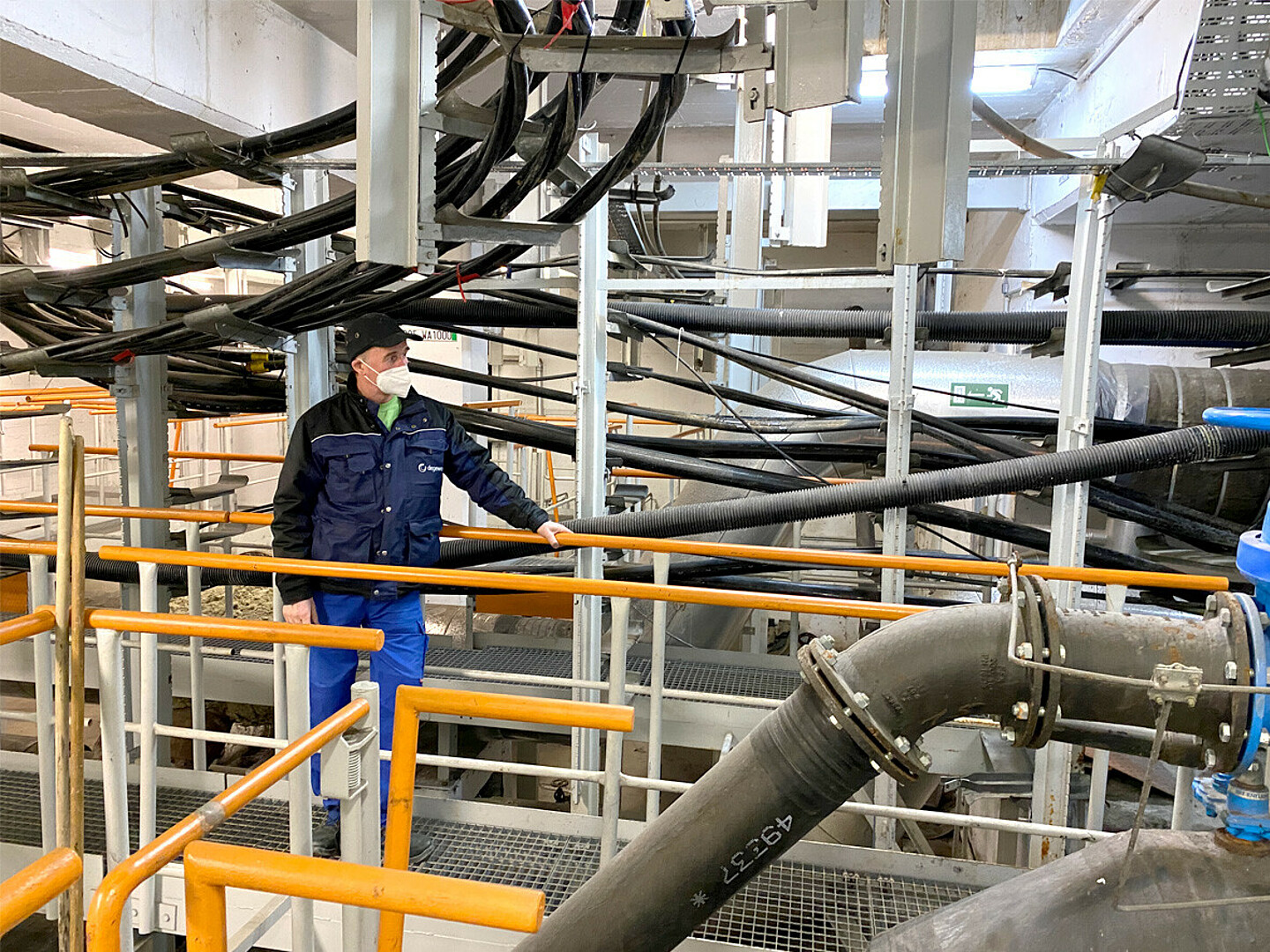 Der Mitarbeiter Andreas Becker-Günther von degewo Technische Dienste GmbH im Sammelkanal Marzahn vor Leitungen und Rohren.