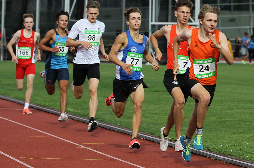 Junge männliche Laufathleten treten auf der Strecke gegeneinander an.
