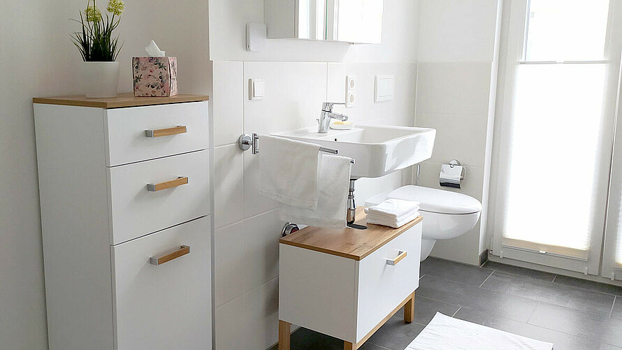Lichtdurchflutetes Badezimmer mit weiß-braunen Möbeln