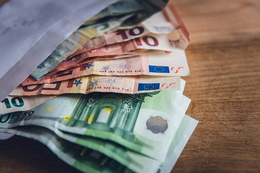 Mehrere Hundert Euro in Scheinen von 5 bis 100 ragen aus einem Briefumschlag