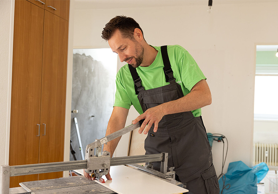 Eine Person arbeitet an einem Tisch mit diversen Handwerksmaterialien.