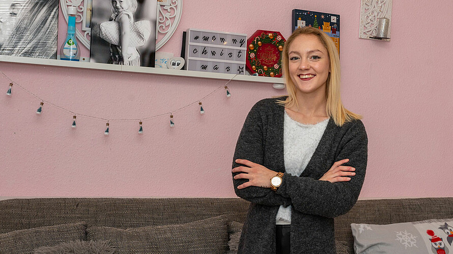 Frau guckt lächelnd in die Kamera.
