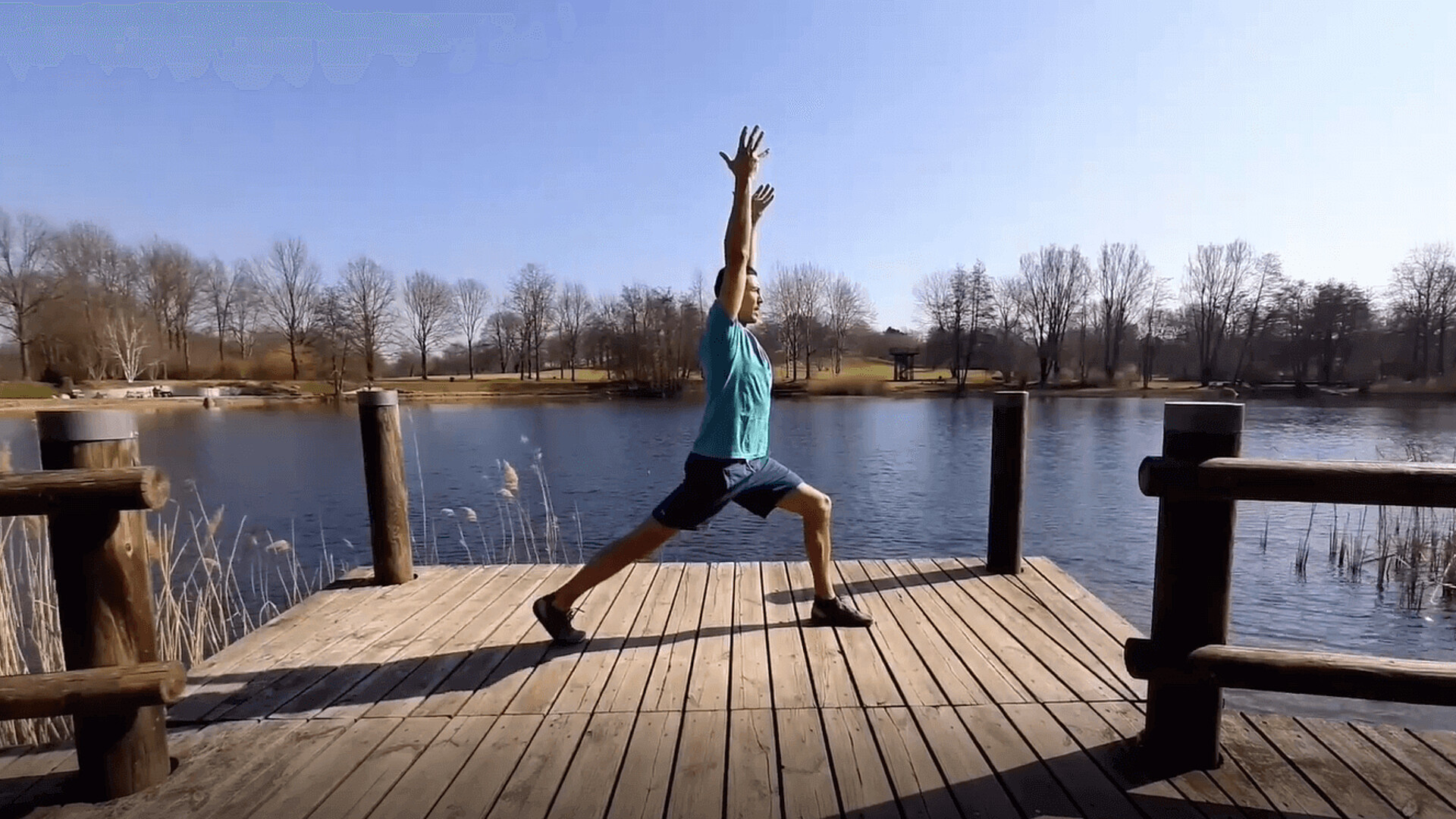 Mann macht eine Yogaübung auf einem Steg.