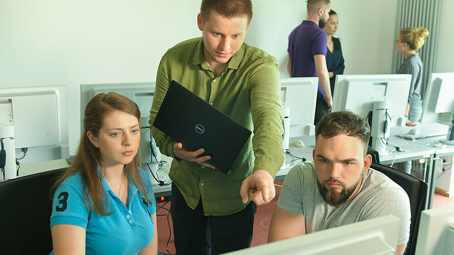 Informatiker schult Kolleginnen und Kollegen am PC