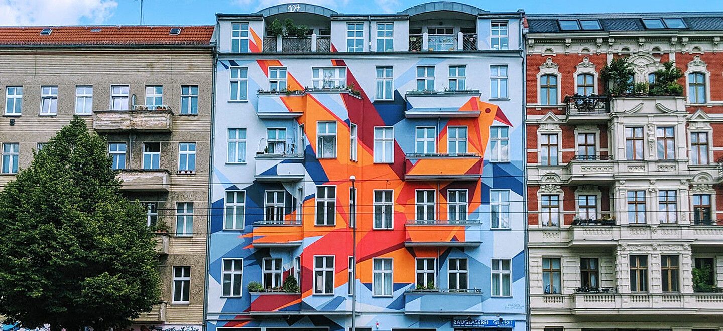 Ein Gebäude mit einem roten und orangen Graffiti-Gemälde darauf