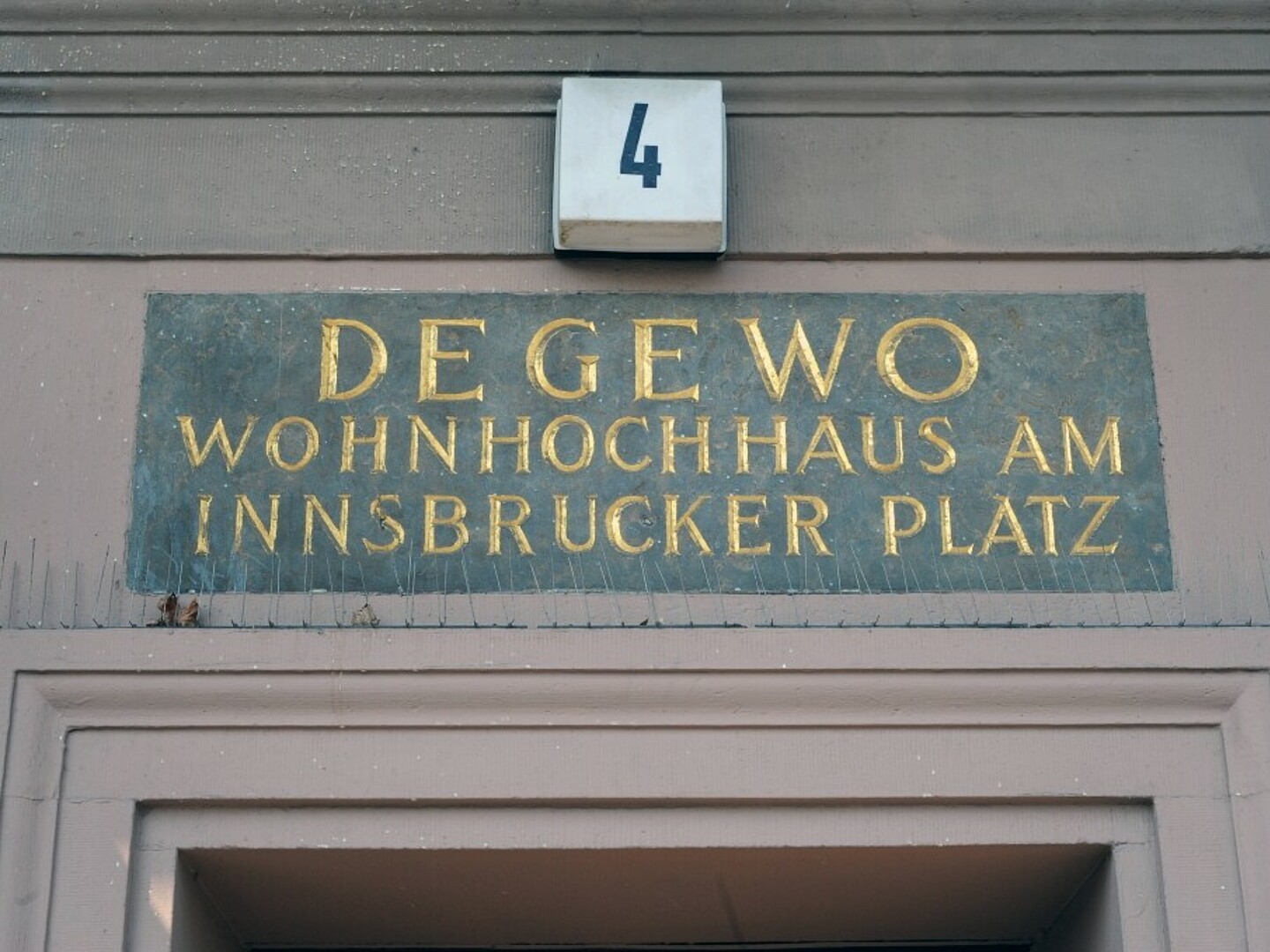 Bild zeigt Schild über der Eingangstür eines Wohnhauses am Innsbrucker Platz.