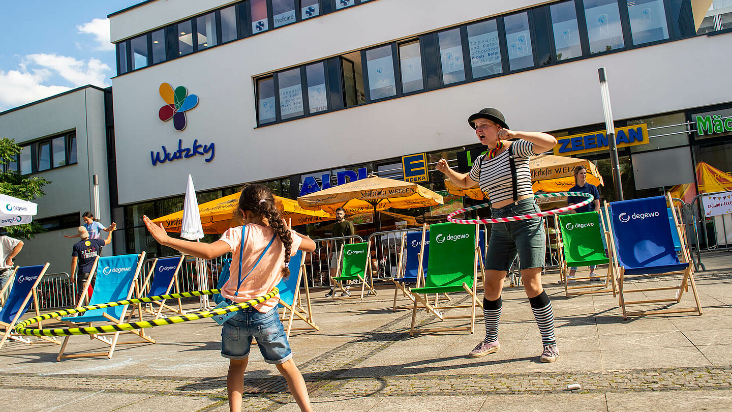 Frau und Mädchen tanzen mit Hula Hoops.