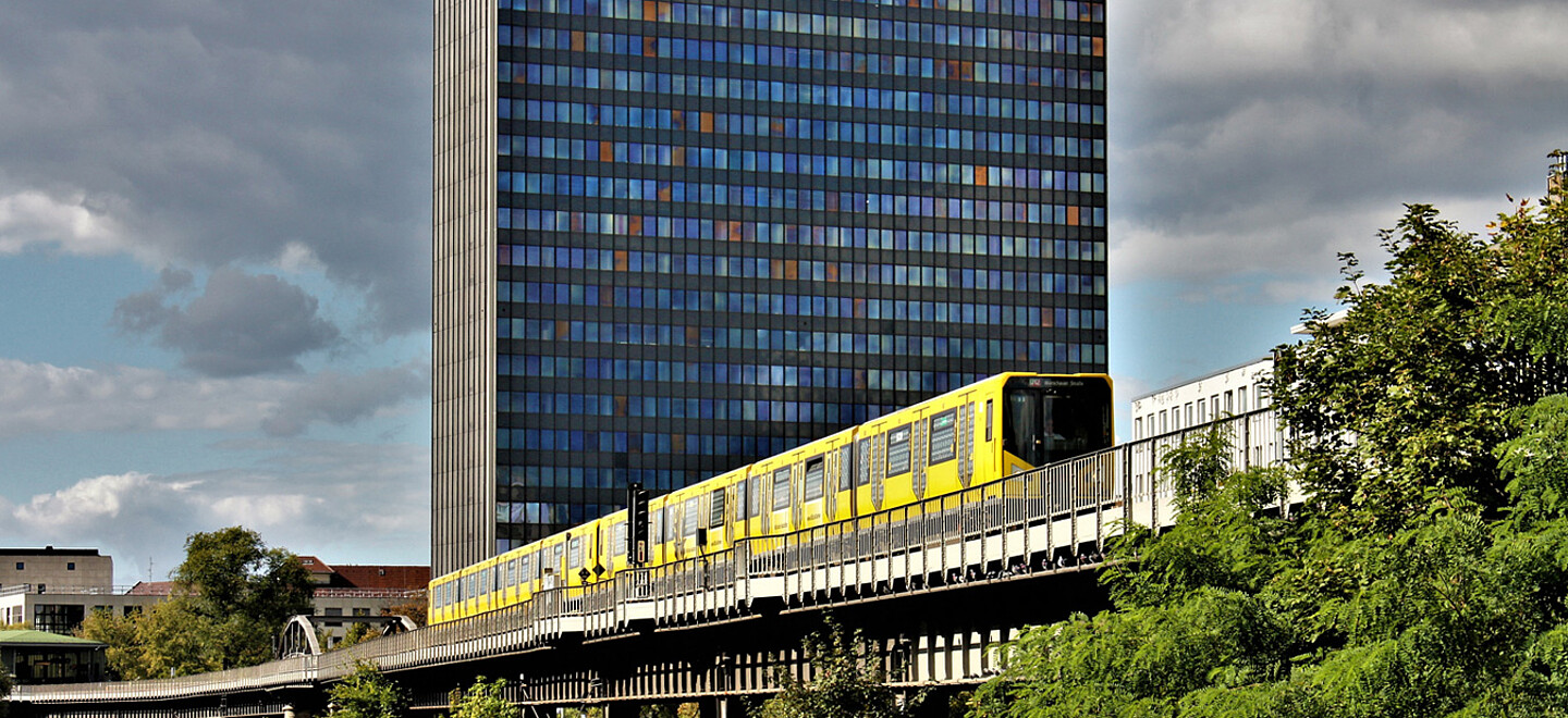 Die Berliner U-Bahn fährt am Postbank-Hochhaus vorbei.