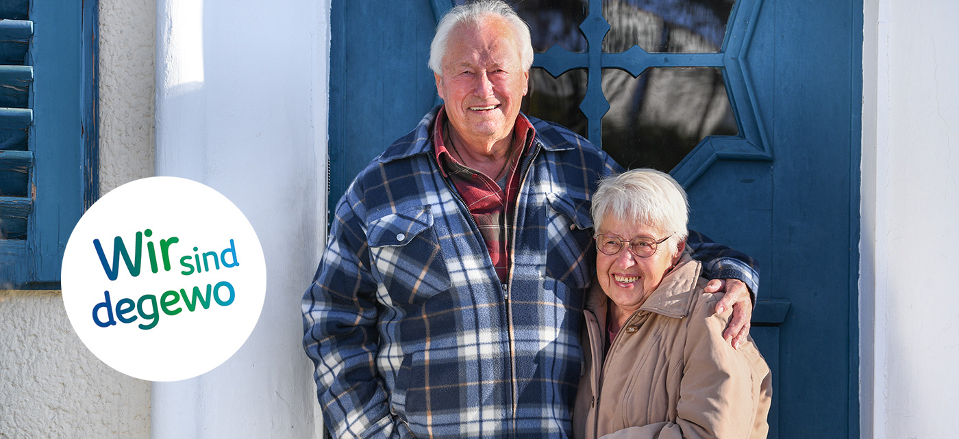 Klaus und Marion Liedtke vor der Eingangstür zu ihrem Haus in der Krugpfuhlsiedlung. Klaus Liedtke hat den Arm um die Schultern seiner Frau gelegt, die beiden lächeln in die Kamera.