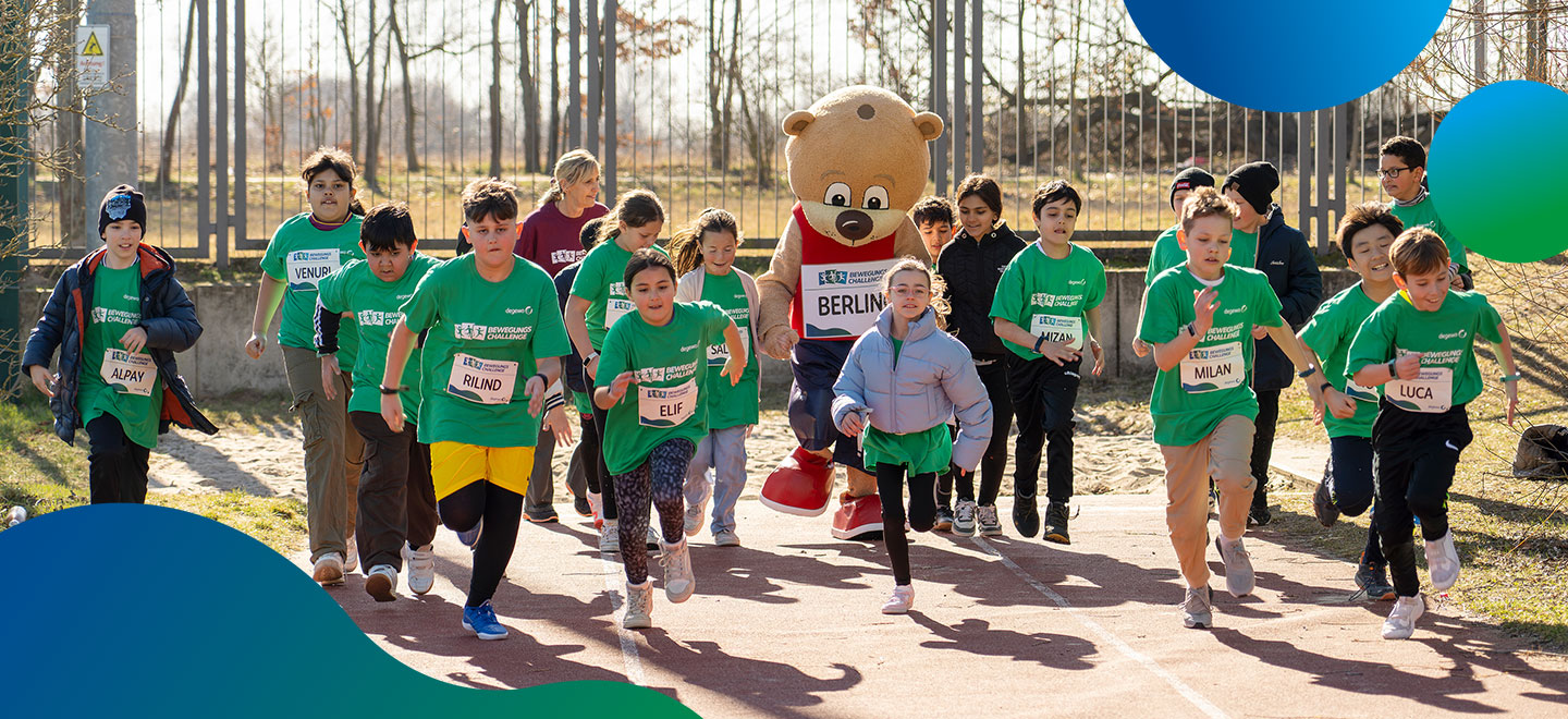 Eine Gruppe Kinder rennt auf einem Sportplatz mit dem Maskottchen Berlino.