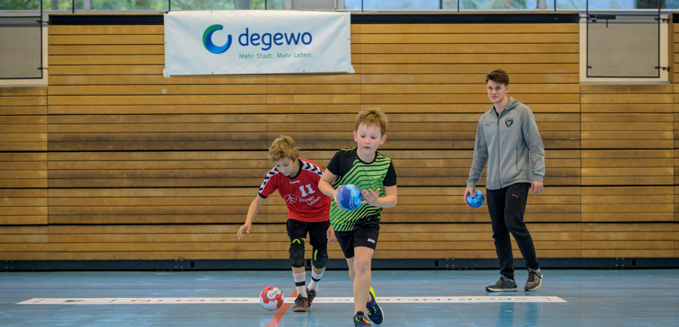 Zwei Jungen laufen und halten den Ball.