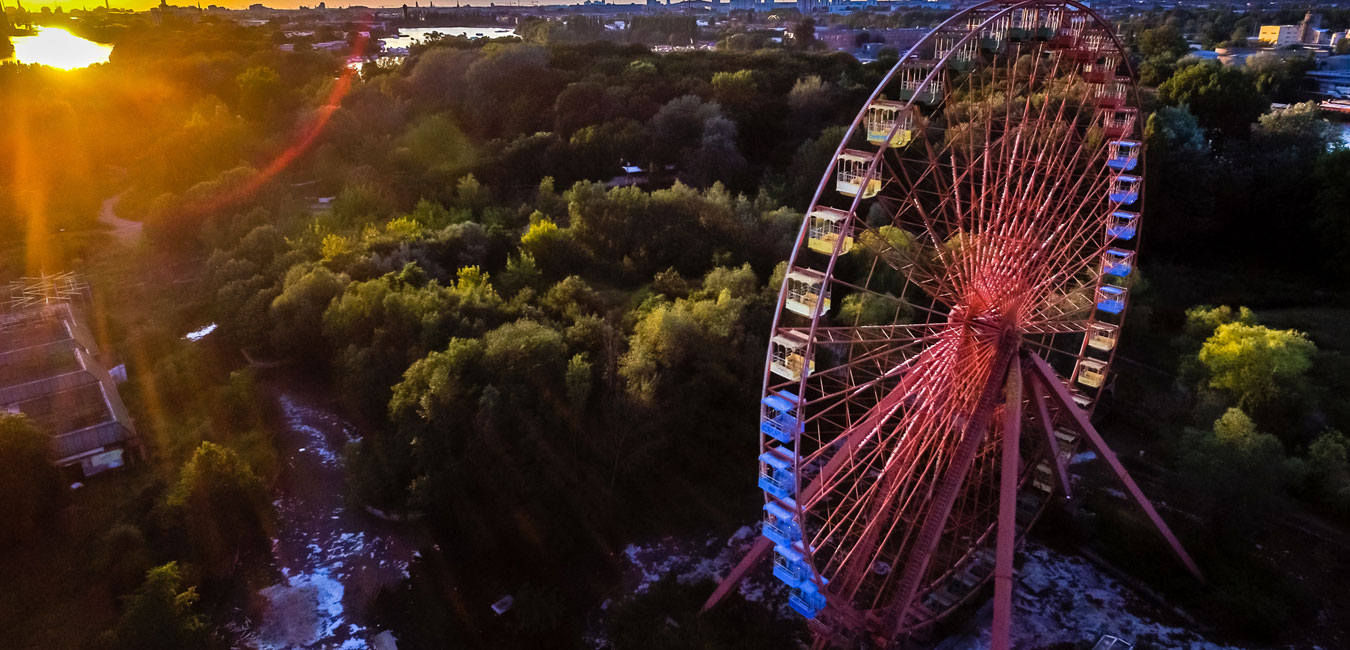 Luftbild von einem Riesenrad mit Wald im Hintergrund.