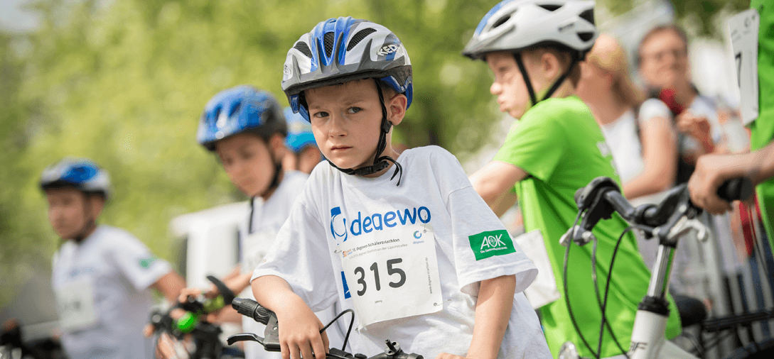 Kind mit Fahrradhelm schaut in die Kamera.