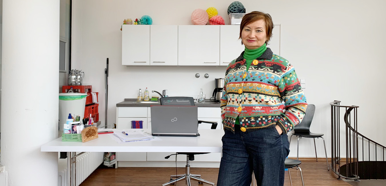 Alma Evert steht in ihrem Büro vorm Tisch