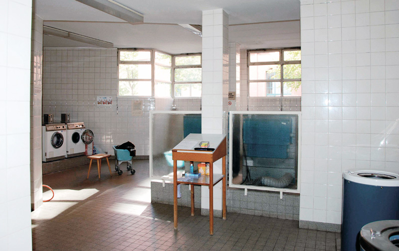 Ein gefliester Raum mit Waschmaschinen 