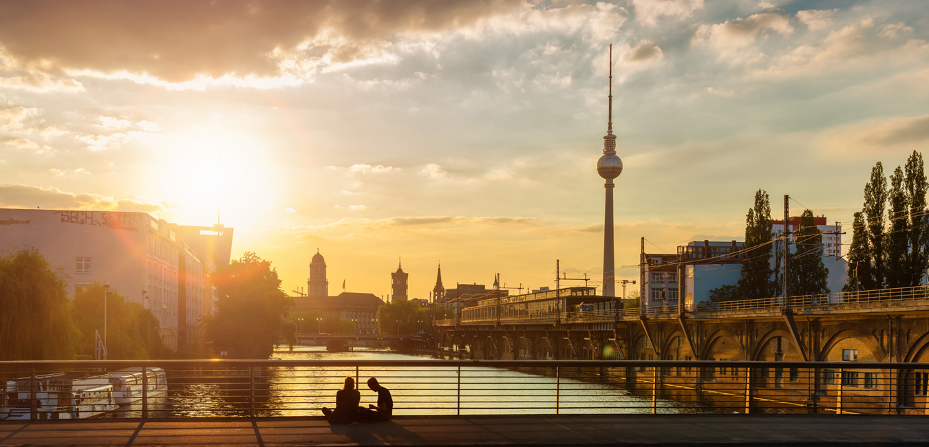 Die Sonne verschwindet im unteren Drittel des Bildes hinter der Berliner Skyline.