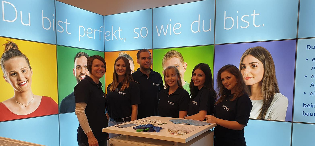 Sechs Auszubildende stehen am Stand von degewo auf einer Messe.