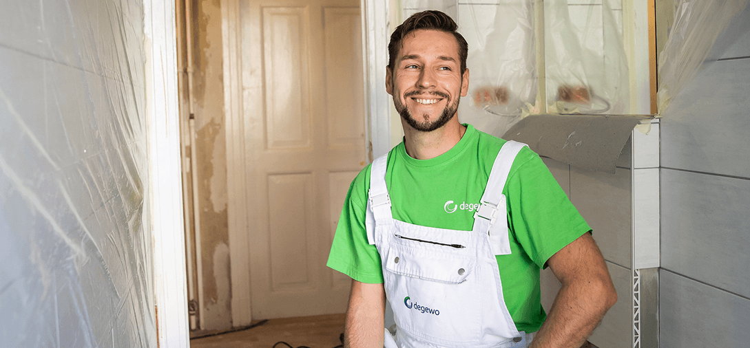 Ein Handwerker der degewo steht in Wohnung, die saniert wird.