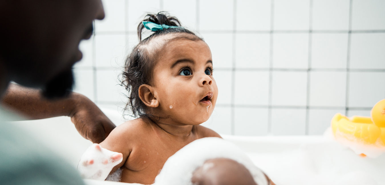 Kleinkind sitzt in einer Badewanne